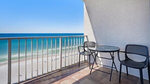 A balcony with a view of the beach, a table, and two chairs. - The Summit 1432 (Panama City Beach)