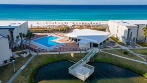Een resort met een zwembad, een overdekt terras en uitzicht op het strand en de oceaan.