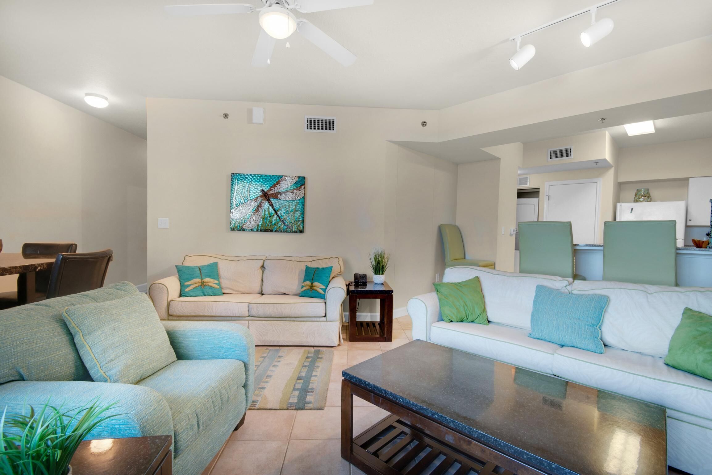 A modern living room with a sofa, coffee table, and a painting on the wall.