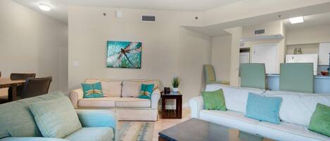 A modern living room with a sofa, coffee table, and a painting on the wall.