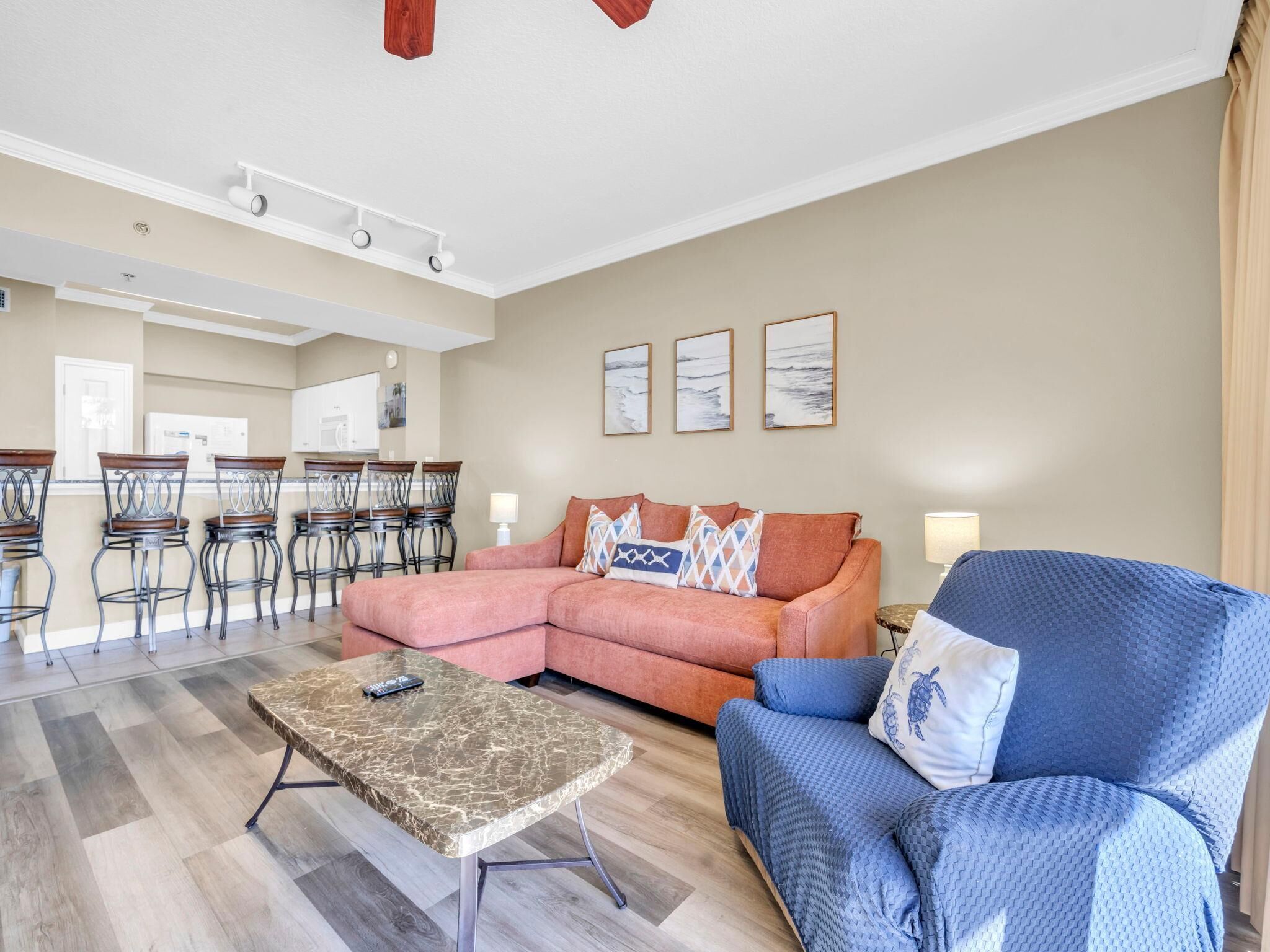 A living room with a sectional sofa, a coffee table, and a dining area with chairs and a table.