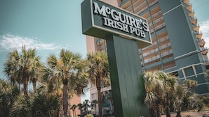 A sign for McGure's Irish Pub with a modern building in the background.