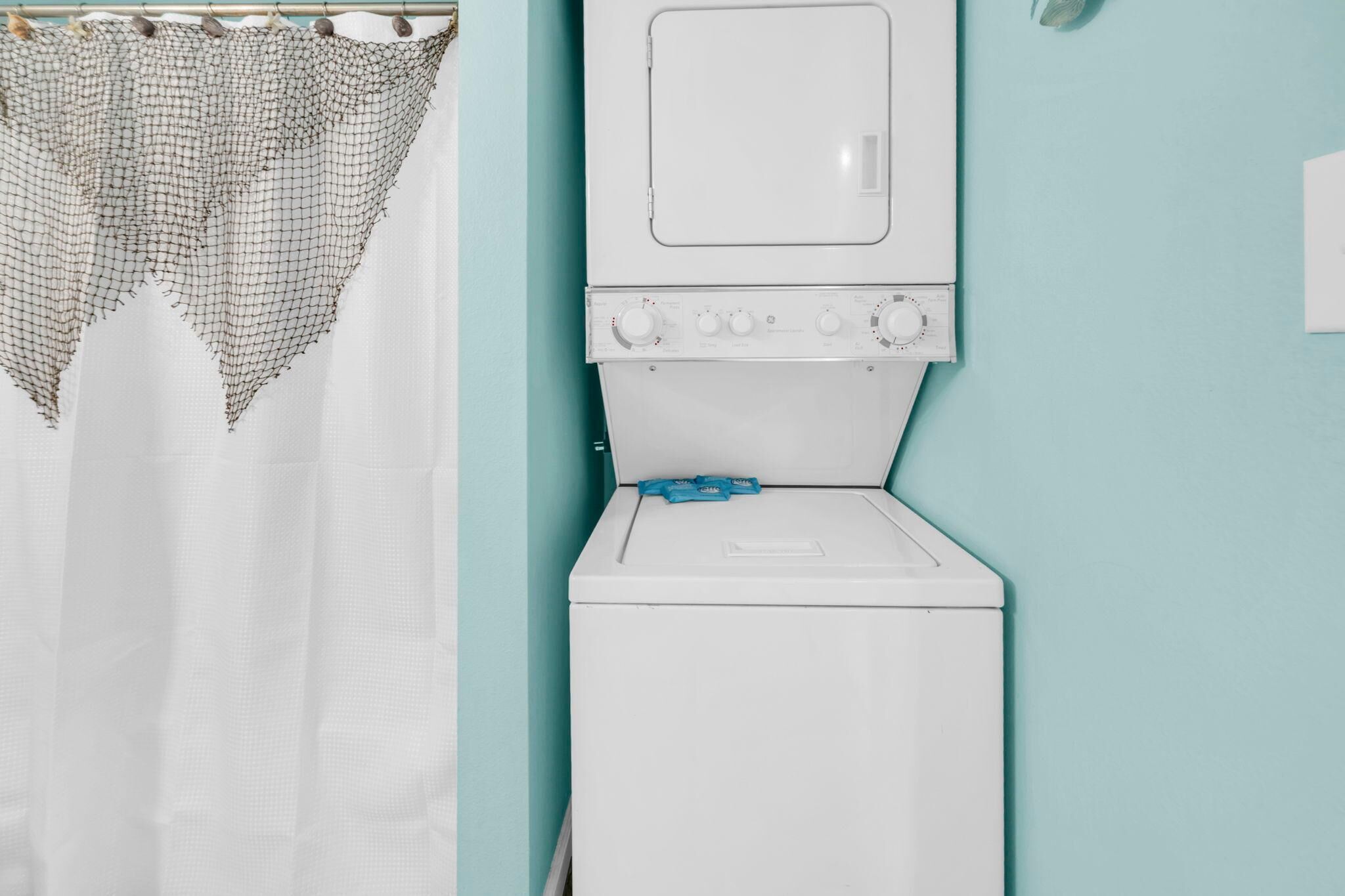A laundry area with a washing machine and a drying rack.
