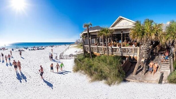 A beachfront hotel with a pool area and a deck overlooking the beach.