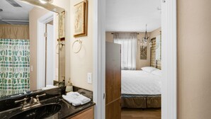 A bathroom with a black sink, a mirror, and a shower curtain with a cactus pattern.
