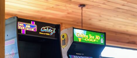 Two arcade machines, one labeled "Galaga" and the other "Hole in One Club."