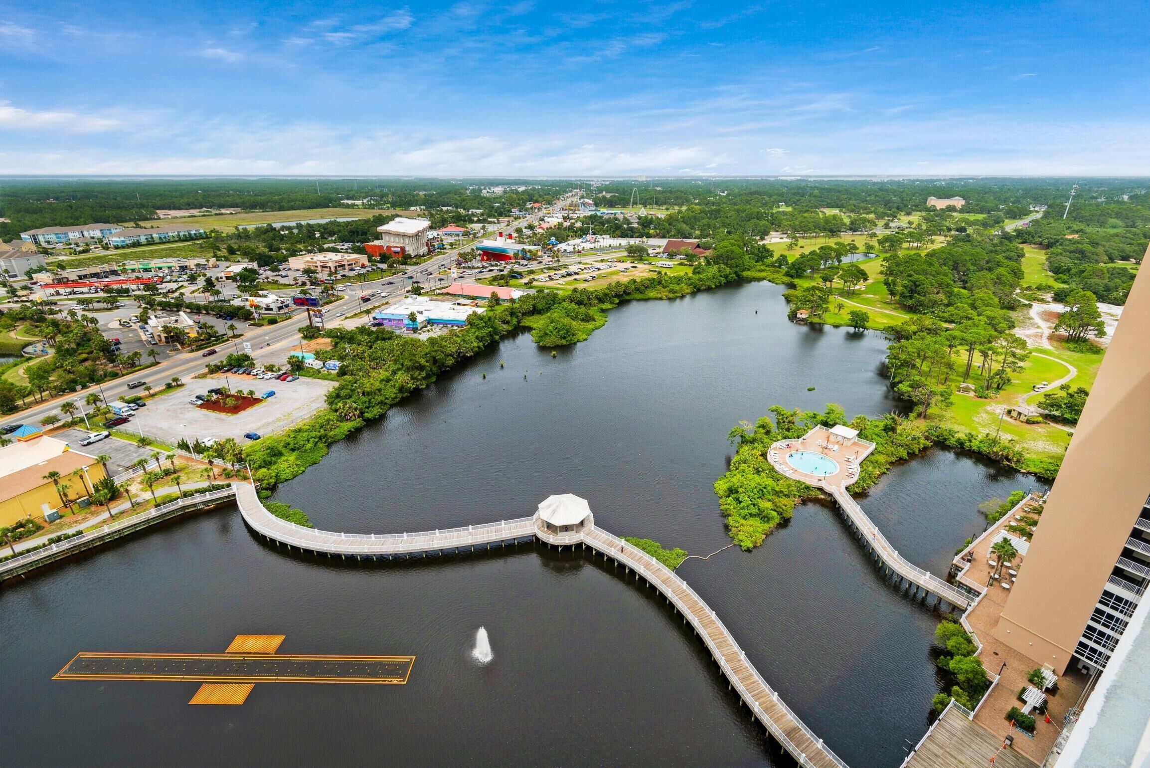 A river with a bridge, a swimming area, and surrounding greenery.