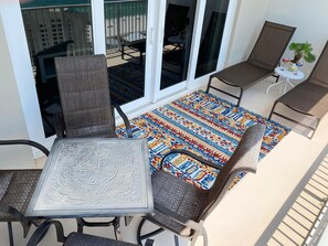 A balcony with a table and chairs, a patterned rug, and a view of the beach. - Laketown Wharf 2118 (Panama City Beach)