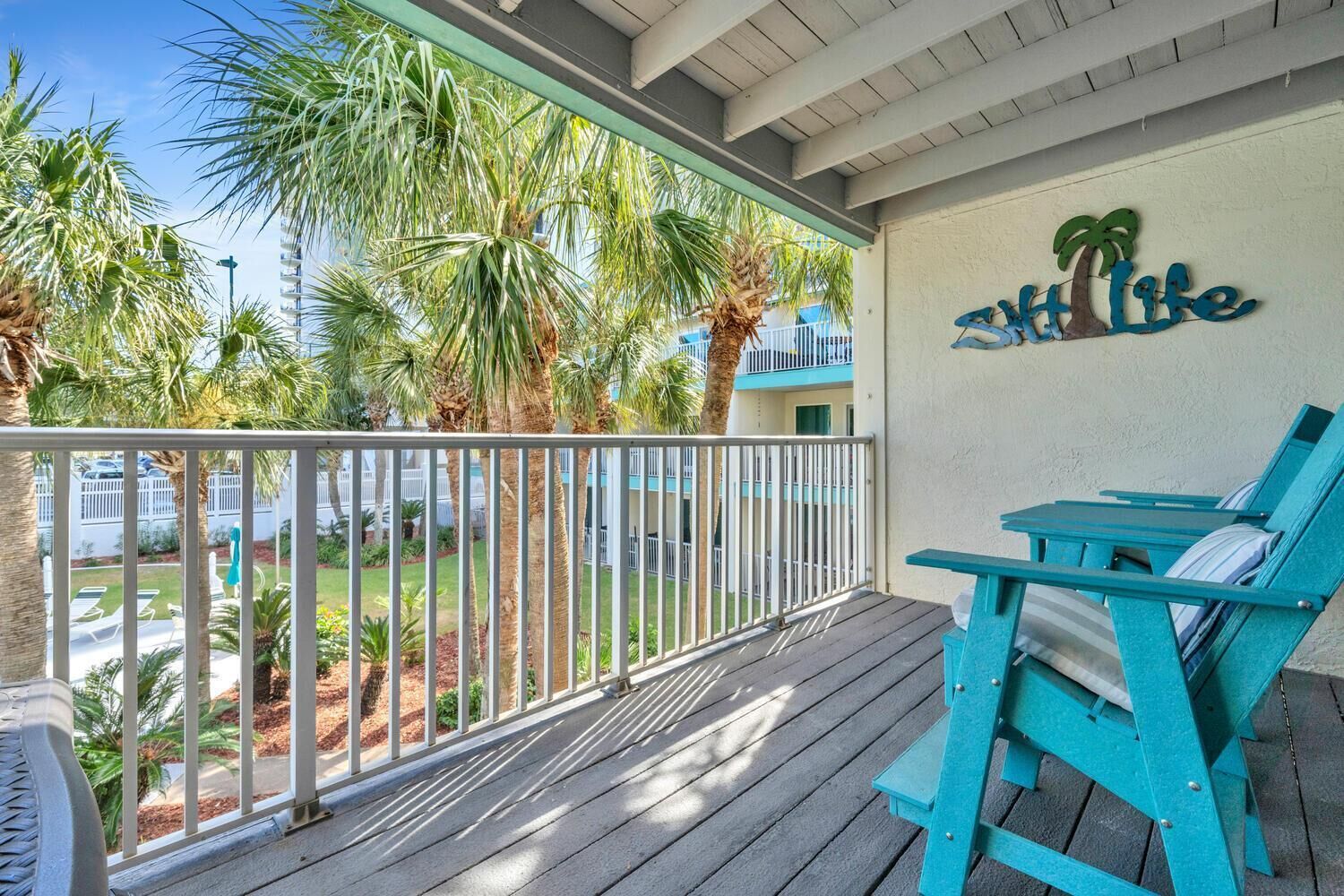 A wooden deck with turquoise chairs and a sign reading "Life".