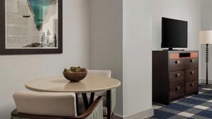A hotel room with a round table, a television on a cabinet, a framed picture on the wall, and a patterned carpet. - Studio next to Gondola 1 (South Lake Tahoe)