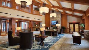 A spacious lobby with high ceilings, wooden beams, and a large chandelier. There are comfortable seating areas and a billiards table. - Studio next to Gondola 1 (South Lake Tahoe)