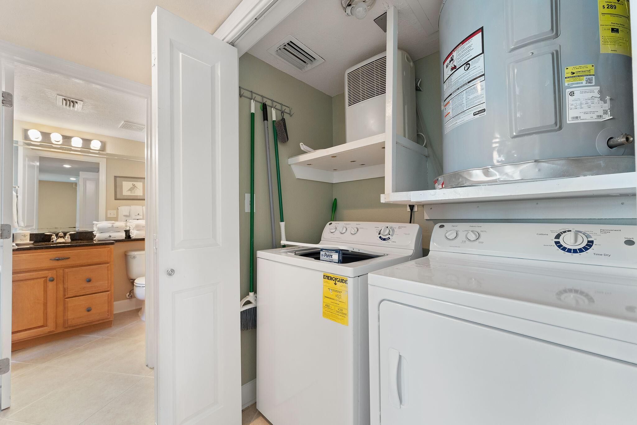 A laundry room with a washer and dryer, a mirror, and a vanity with a sink.