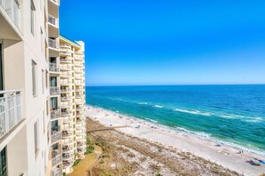 Un hôtel situé en bord de mer, doté de nombreux balcons offrant une vue sur l’océan.