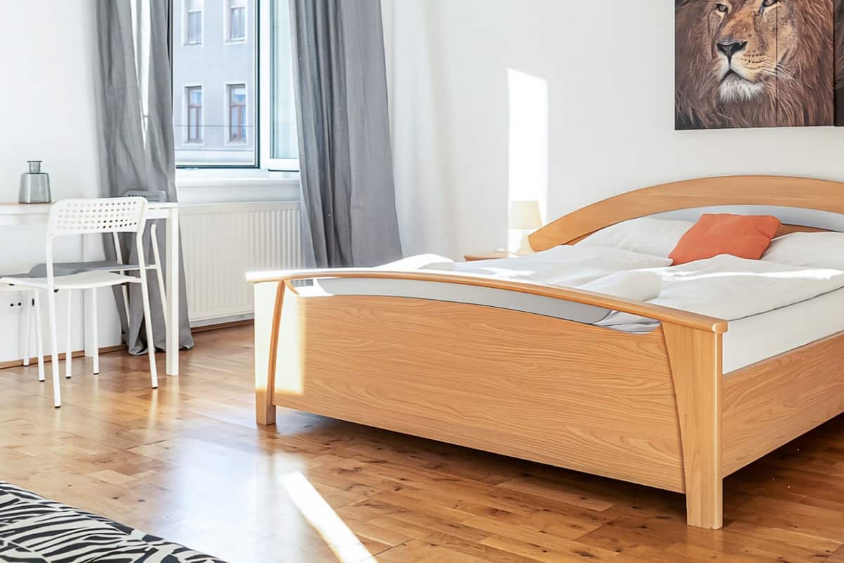Un dormitorio moderno con una cama de madera, un escritorio y una silla.