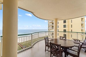 Enjoy the ocean view from this balcony with a round table and four chairs.