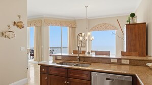 A kitchen with a dishwasher, double sink, and wooden cabinets.