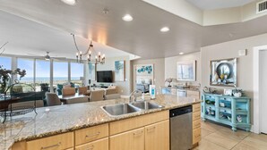 A spacious kitchen with granite countertops, stainless steel appliances, and a view of the ocean. - Caribe D411 (Orange Beach)
