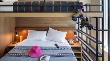 A bunk bed with a headboard, a bedside table with a lamp, a remote control, a pink hat, headphones, and roller skates.