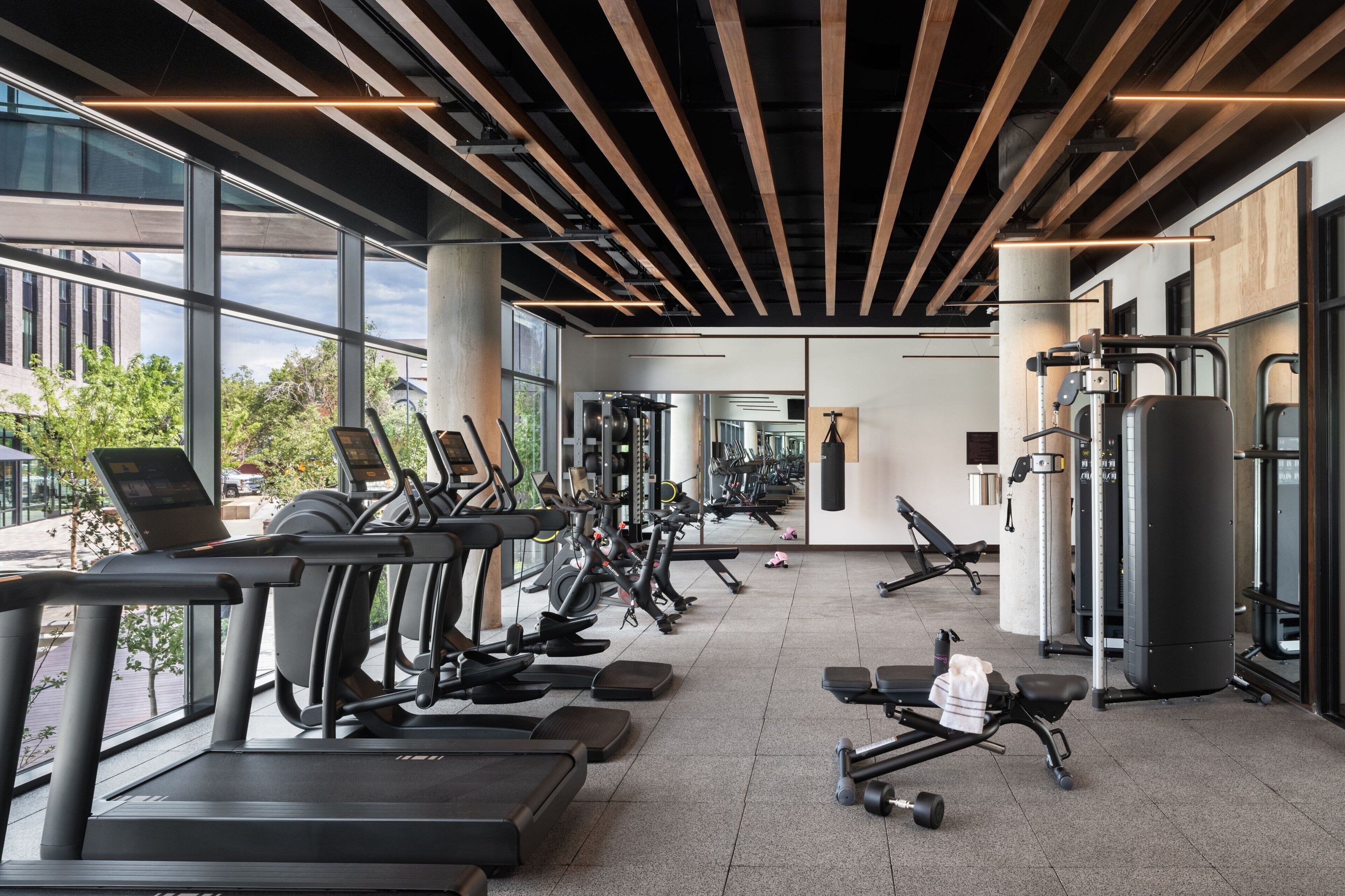 Ein modernes Fitnessstudio mit Laufbändern, Crosstrainern und Gewichtsmaschinen.