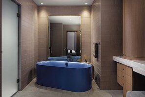 A modern bathroom with a large bathtub, a mirror, and wooden cabinetry. - Courtyard By Marriott Yerevan (Yerevan)