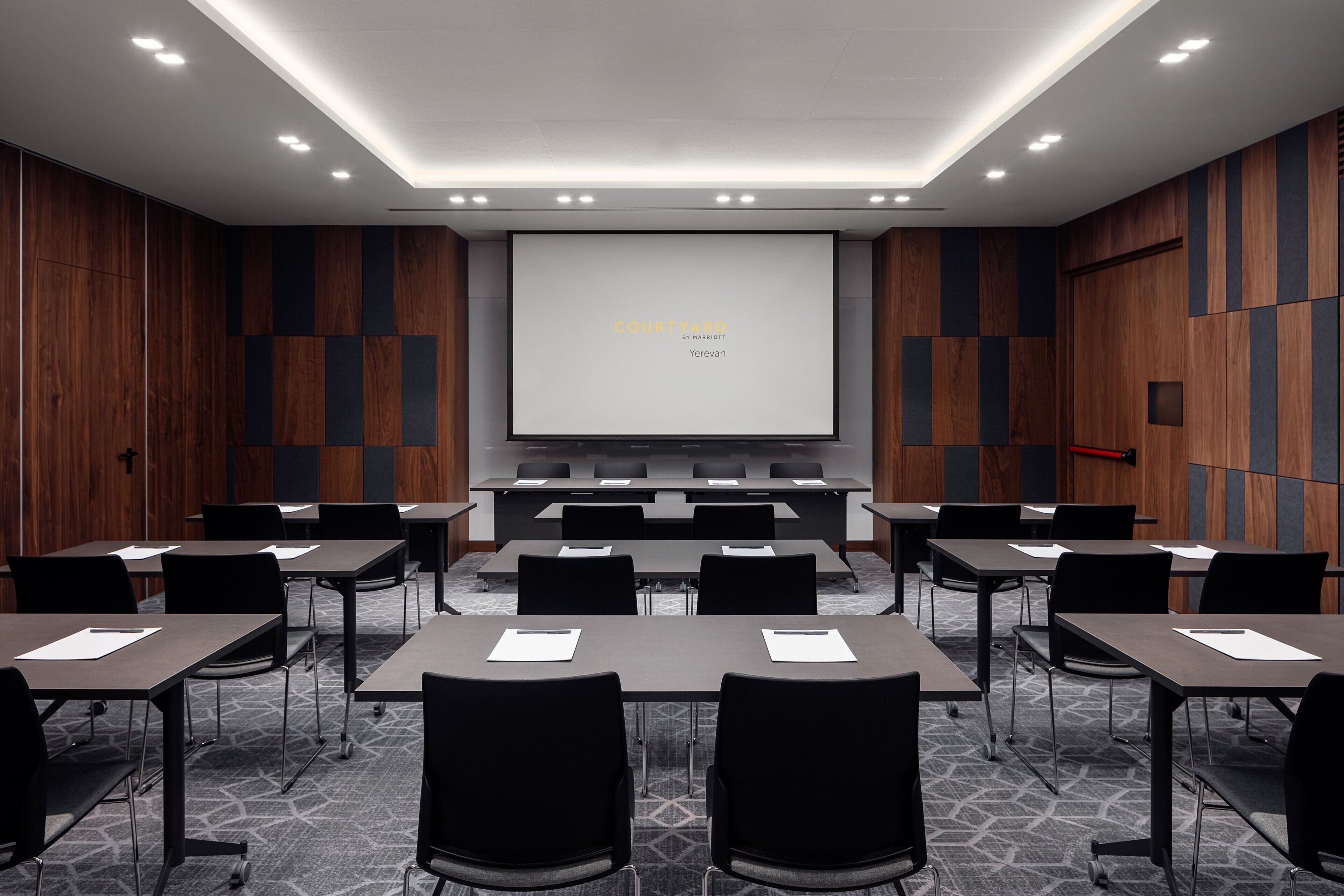 A conference room with a large screen displaying "COURT TAVERS" and "Yerevan".