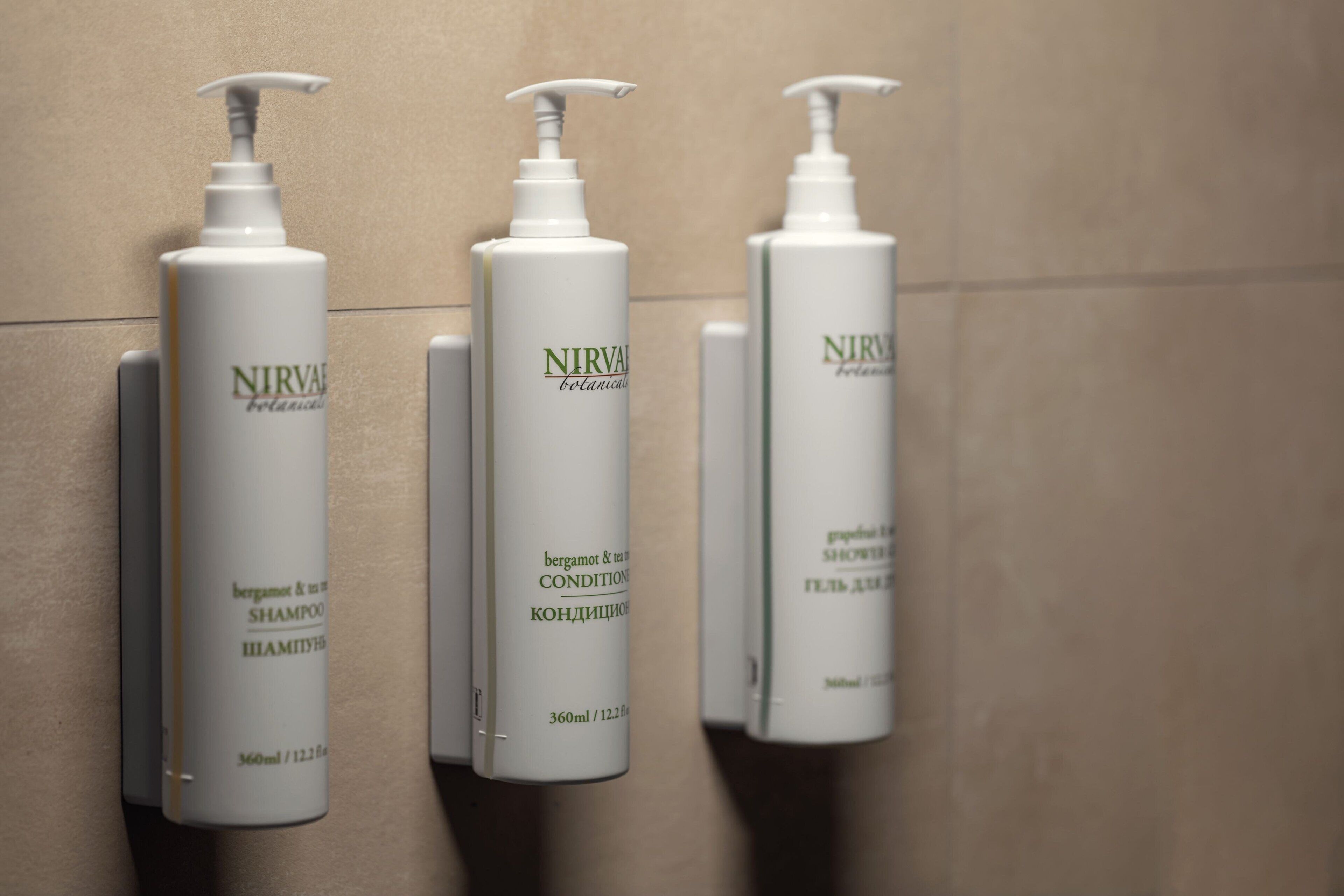 Tres botellas de champú y acondicionador botánico Nirvana.