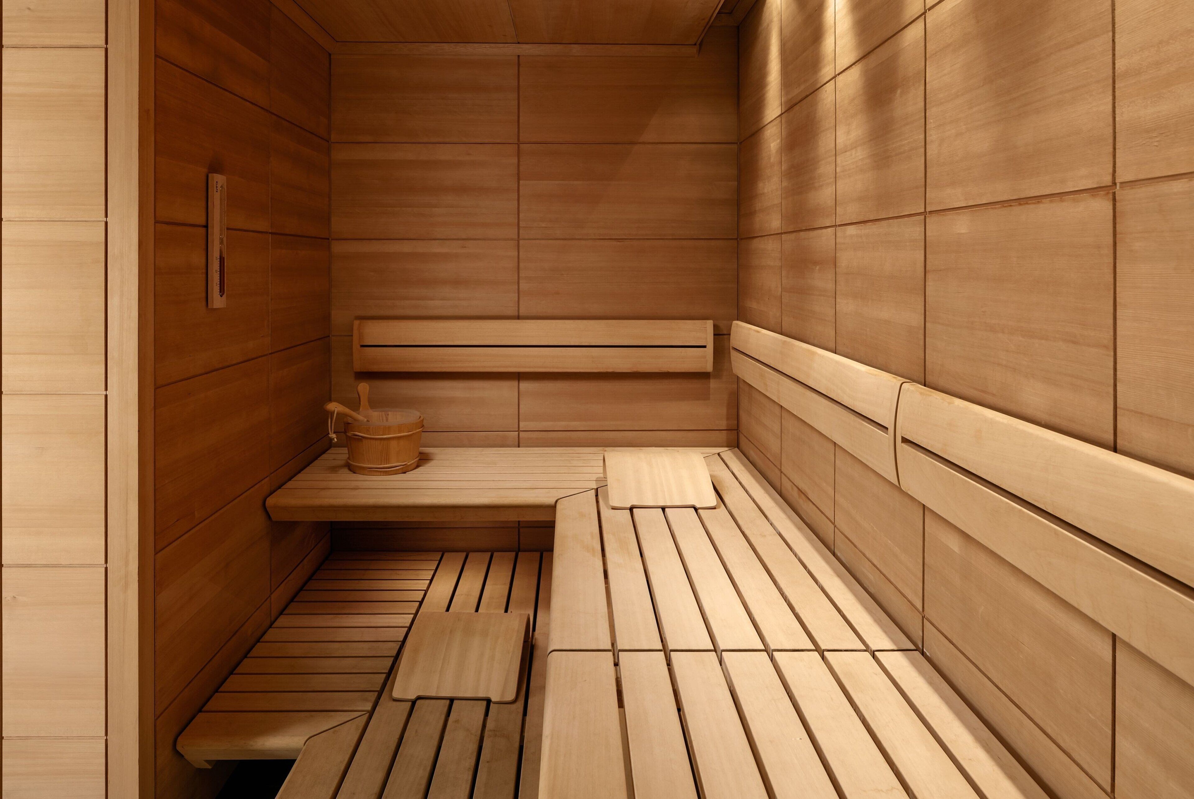 En sauna med træbænke og en bænk, trævægge og en trægulv.