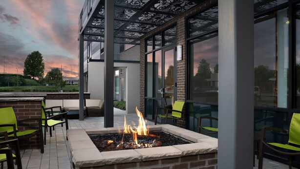 An outdoor seating area with a fire feature, modern furniture, and a view of the sky. - Springhill Suites by Marriott Lexington Fritz Farm (Lexington)