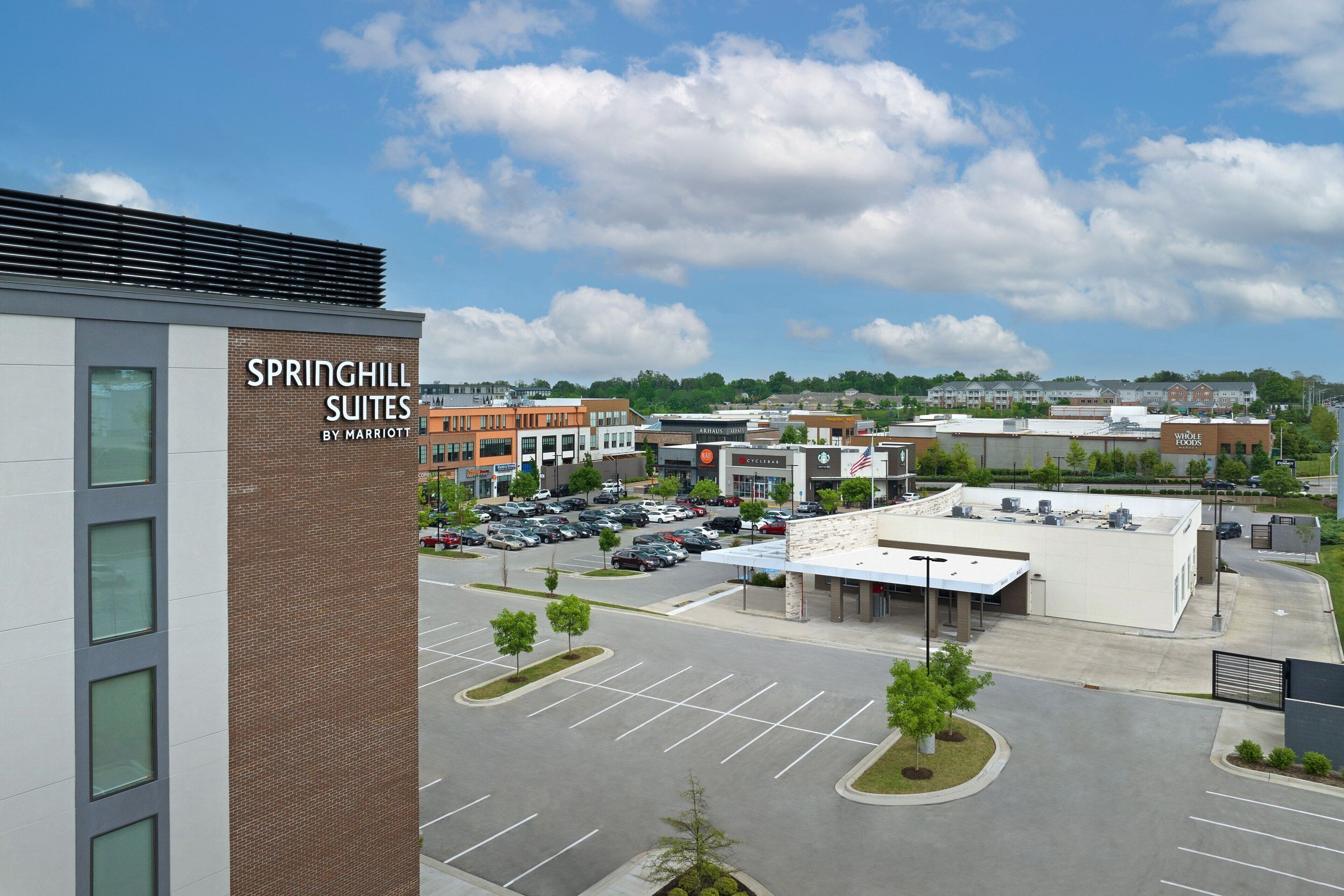 Hotel Springhill Suites by Marriott, con estacionamiento y edificios circundantes.