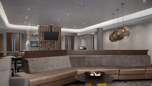 A modern interior with a sectional sofa, a round coffee table, and a minimalist design. - Springhill Suites by Marriott Lexington Fritz Farm (Lexington)