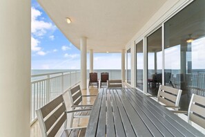 Enjoy ocean views from this covered outdoor space with a long table and comfortable seating.