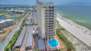 Un hôtel à plusieurs étages doté d’une piscine, d’un accès à la plage et offrant une vue sur l’océan.