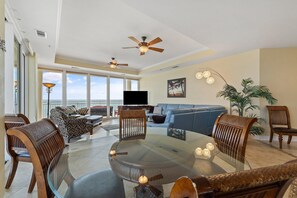 Relax in this stylish living area with a round dining table, comfortable sofa, and armchair.