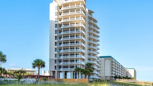 Un hôtel à plusieurs étages, doté de balcons, d’une partie supérieure incurvée et d’un toit plat.
