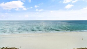 Une plage avec un ciel dégagé et une mer calme.