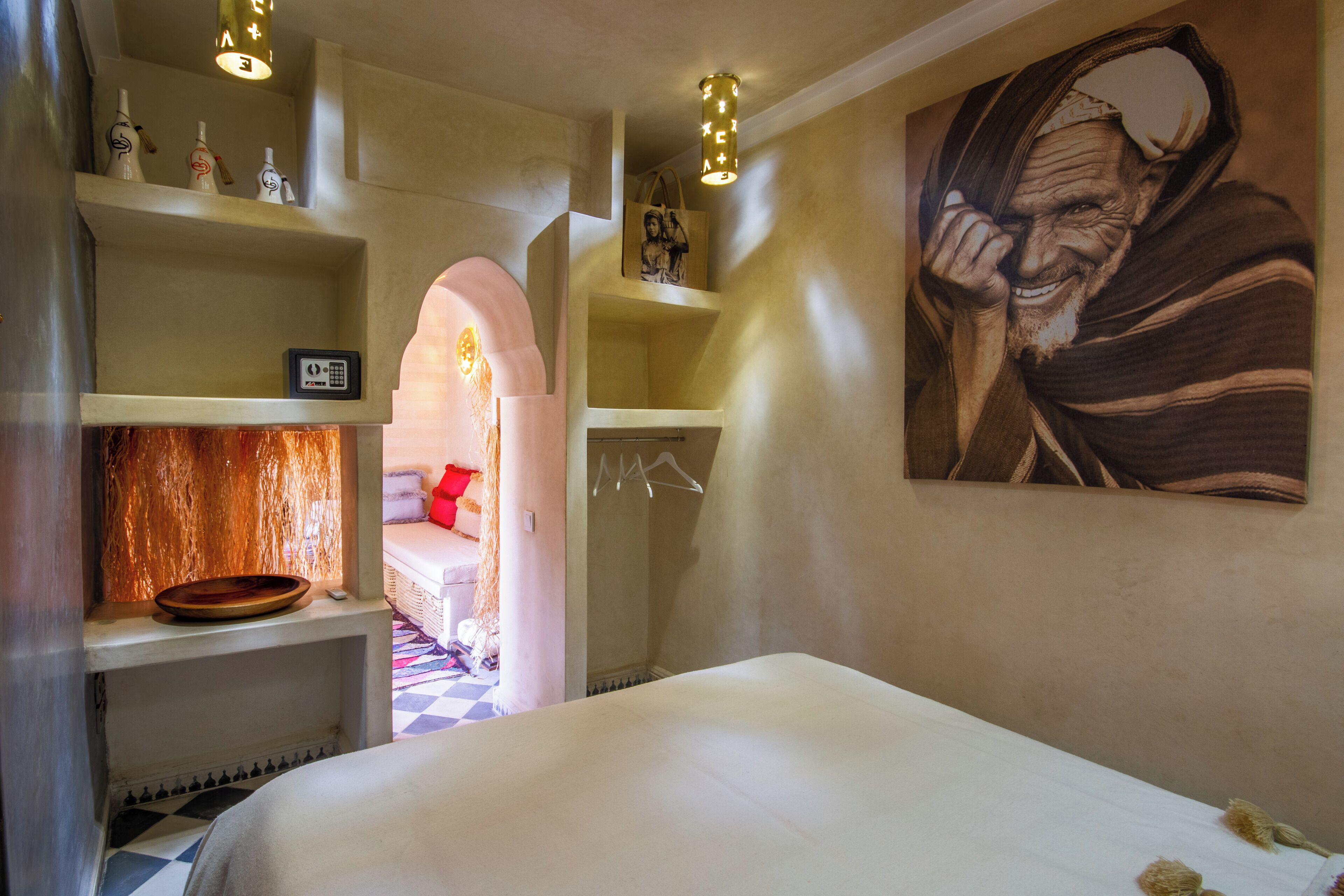 Una habitación de hotel con una cama, un baño y un pasillo que conduce a una sala de estar.