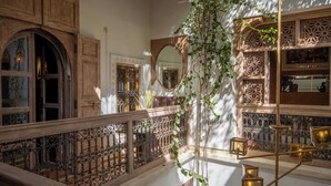 Una gran escalera con barandales ornamentales y una planta colgante.