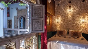 Una habitación de diseño tradicional, con una pared grande y ornamentada y una cama con colcha blanca.
