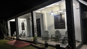 A house with a covered porch, potted plants, and outdoor seating. - Coastal Paradise Steps from Secluded Beaches & Stunning views in Islote, Arecibo (Islote)