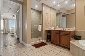 Enjoy a refreshing walk-in shower with a glass door, large mirror, and wooden vanity.