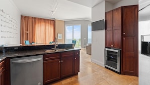 A modern kitchen with dark wooden cabinets, a stainless steel dishwasher, and an oven.
