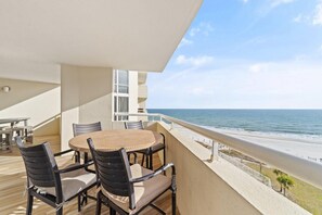 A balcony with a round table and chairs, overlooking a beach and ocean. - Perdido Sun 616 (Pensacola)