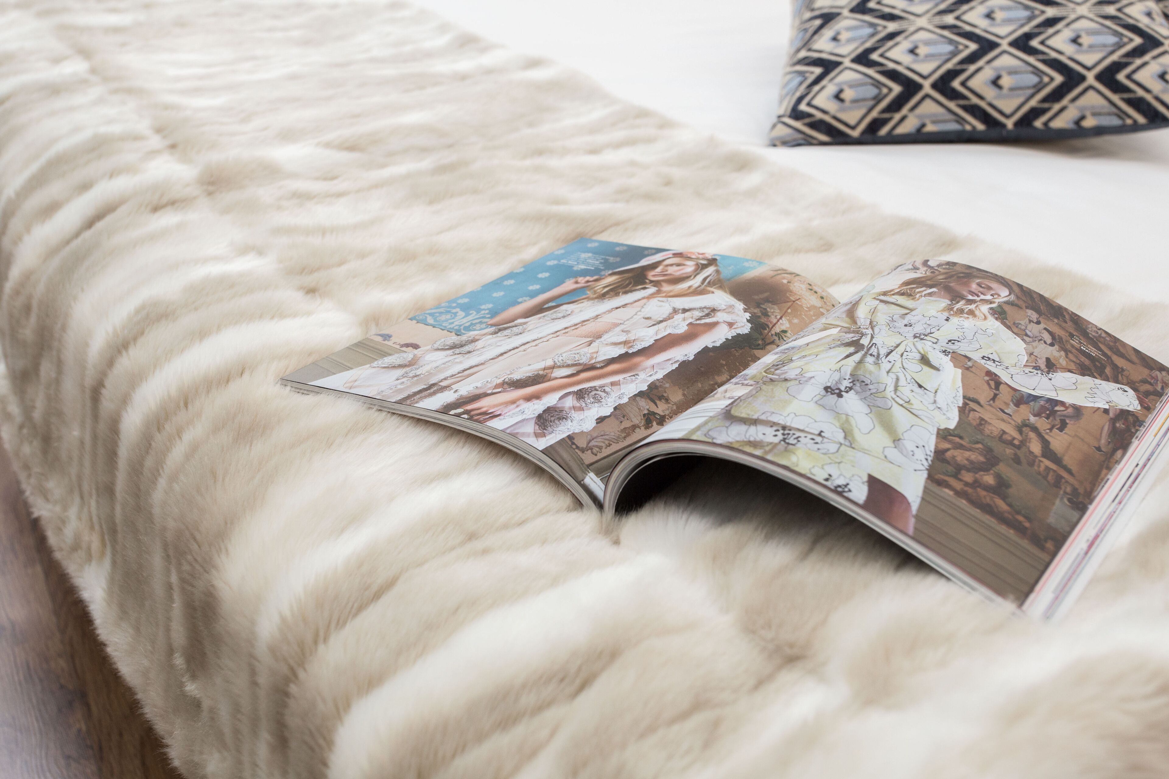 Un magazine posé sur un pouf recouvert de fourrure.