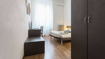 Un dormitorio moderno con cama, escritorio y armario.