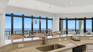 A kitchen with a large window, a sink, and a dishwasher.