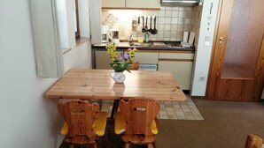 A compact kitchen with a wooden table and chairs, a coffee maker, and a dish rack. - Erholsame, Familienfreundliche 1-zi Fewo am Bach Bzw. am Ski-lift (Todtnau)