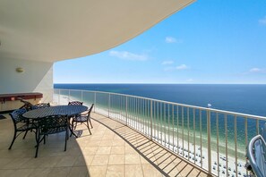 A balcony with a table and chairs overlooking a beach. - Turquoise C2106 (Orange Beach)