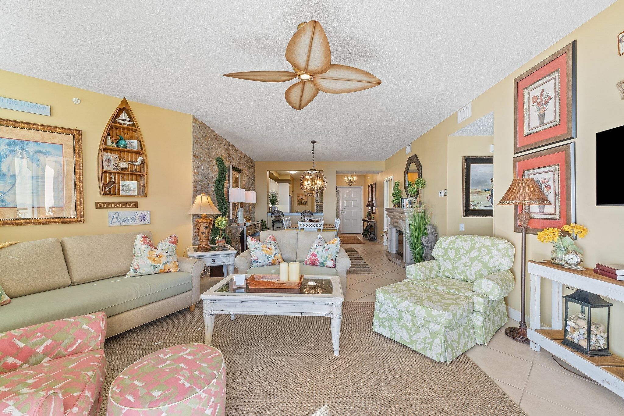 A spacious living room with a large ceiling fan, a fireplace, and a dining area.