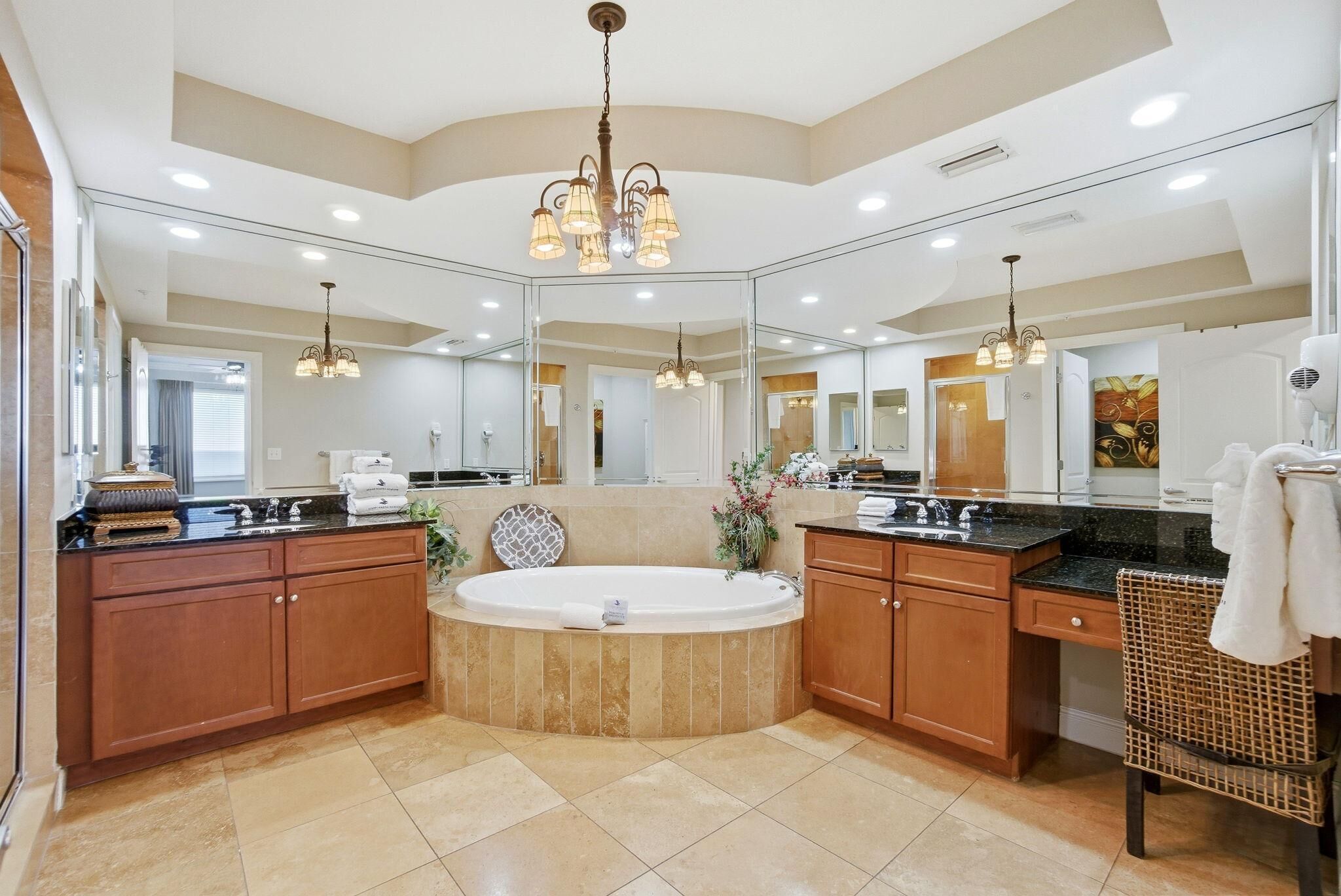 A spacious bathroom with a large bathtub, wooden cabinets, and a mirror.