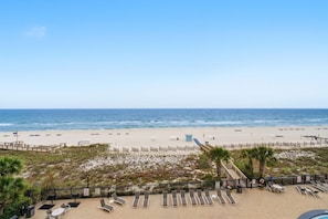 A beach view with lounge chairs, a pool, and a wooden deck. - Palacio 302 (Pensacola)